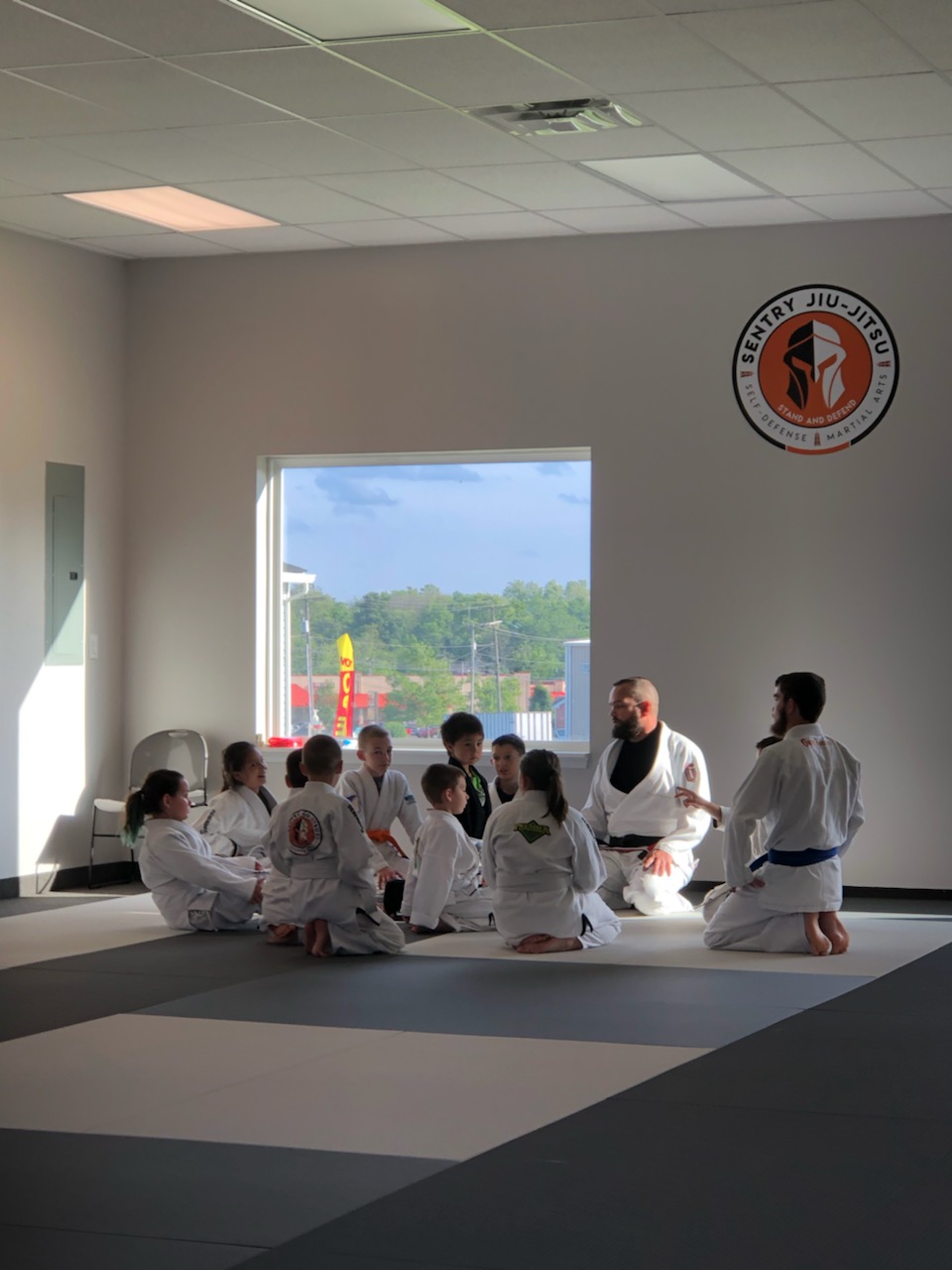 Sentry Jiu-Jitsu kids and instructors gathered on the mats at the Gilbertsville academy